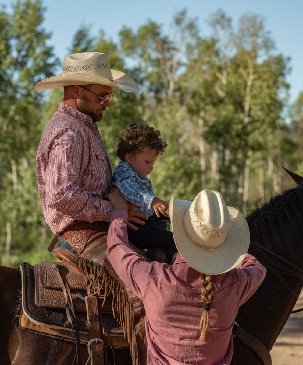 L2 Ranch family passing child on horseback, three generations